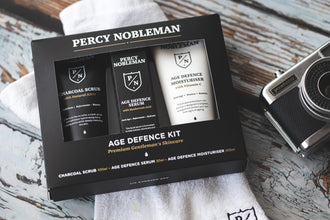 Percy Nobleman Age Defence Kit, a men's skincare set containing Charcoal Face Scrub (with Natural AHAs), ultra-hydrating Facial Serum (with Hyaluronic Acid), and Moisturiser (with Vitamin C)